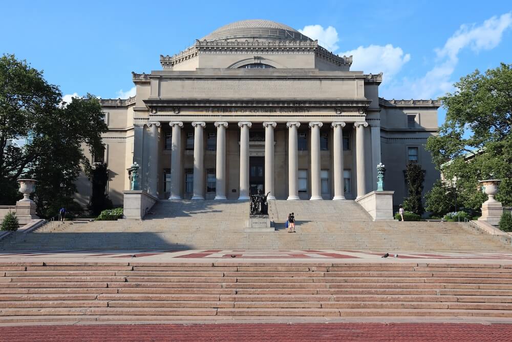 Happy graduate student with a certificate after graduation ceremony at the university. Columbia University campus