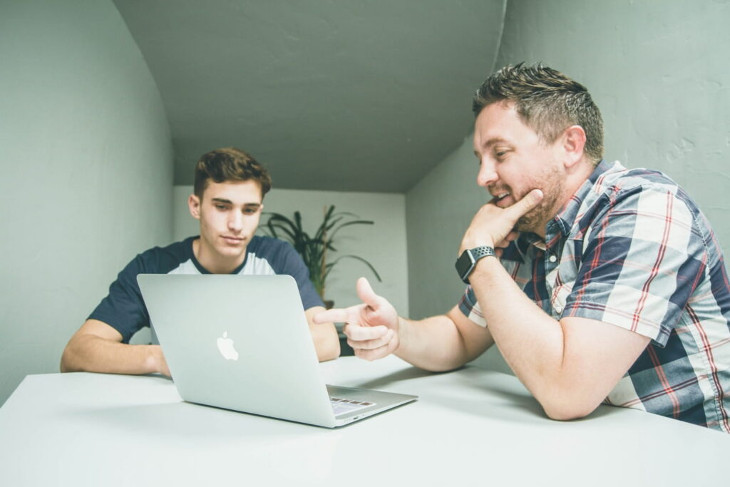College student career coaching session with advisor reviewing job search strategy on laptop