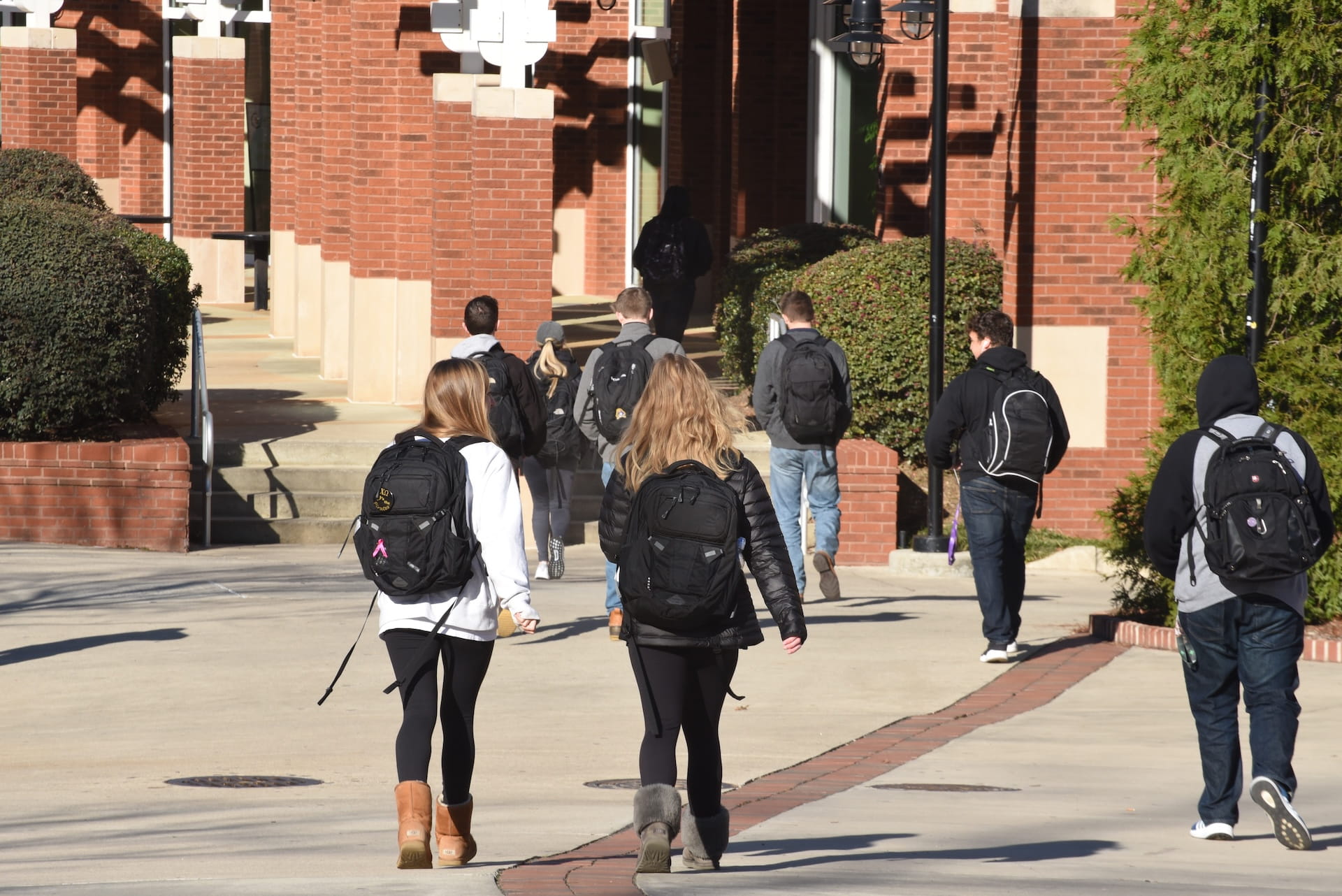 College school students walking with backpacks toward a college campus building